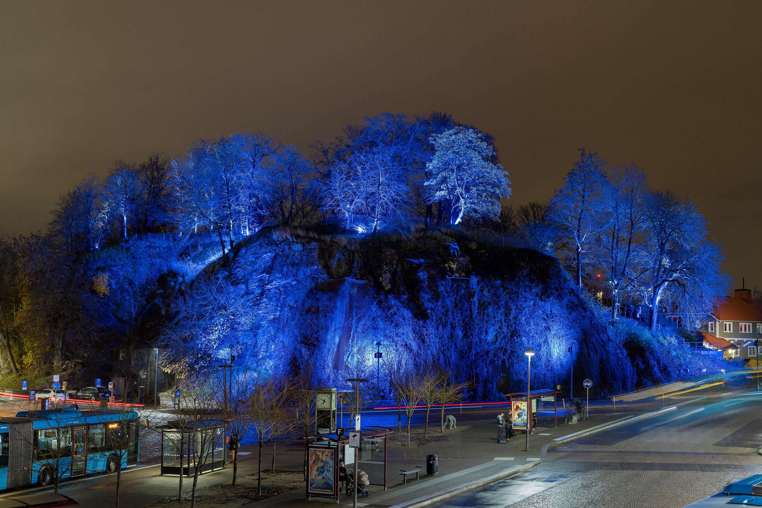 Kvällsmörker vid resecentrum med ett upplyst berg i blå färgtoner