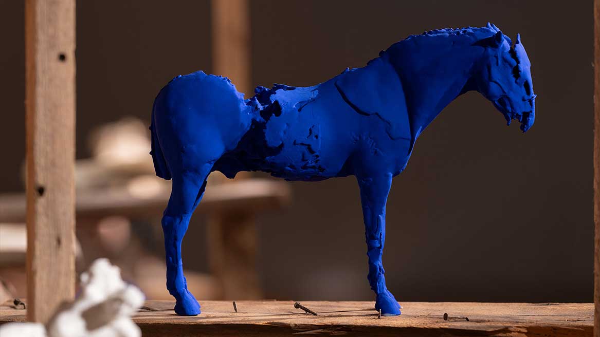 Liten skulptur av häst i blått.