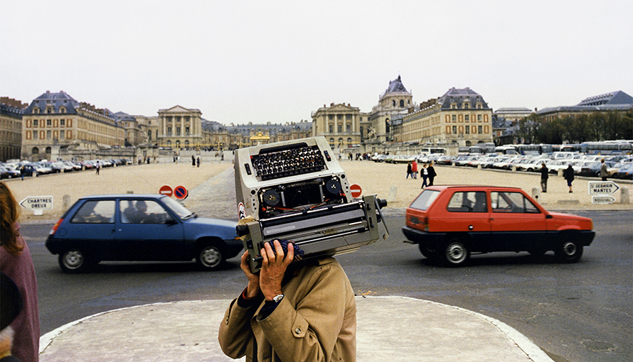 Fotografi av Lars Tunbjörk på man som bär skrivmaskin i Paris.