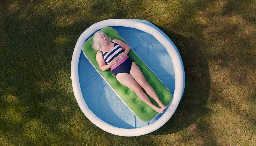 kvinna i 60-årsåldern ligger i en pool