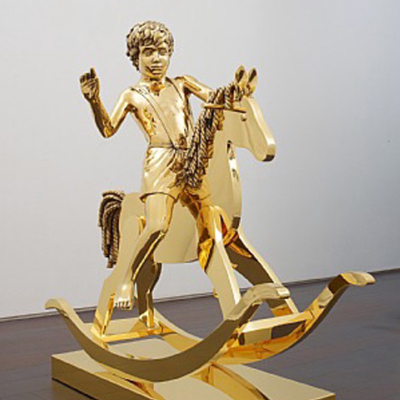 Skulptur av en pojke på hans gunghäst.