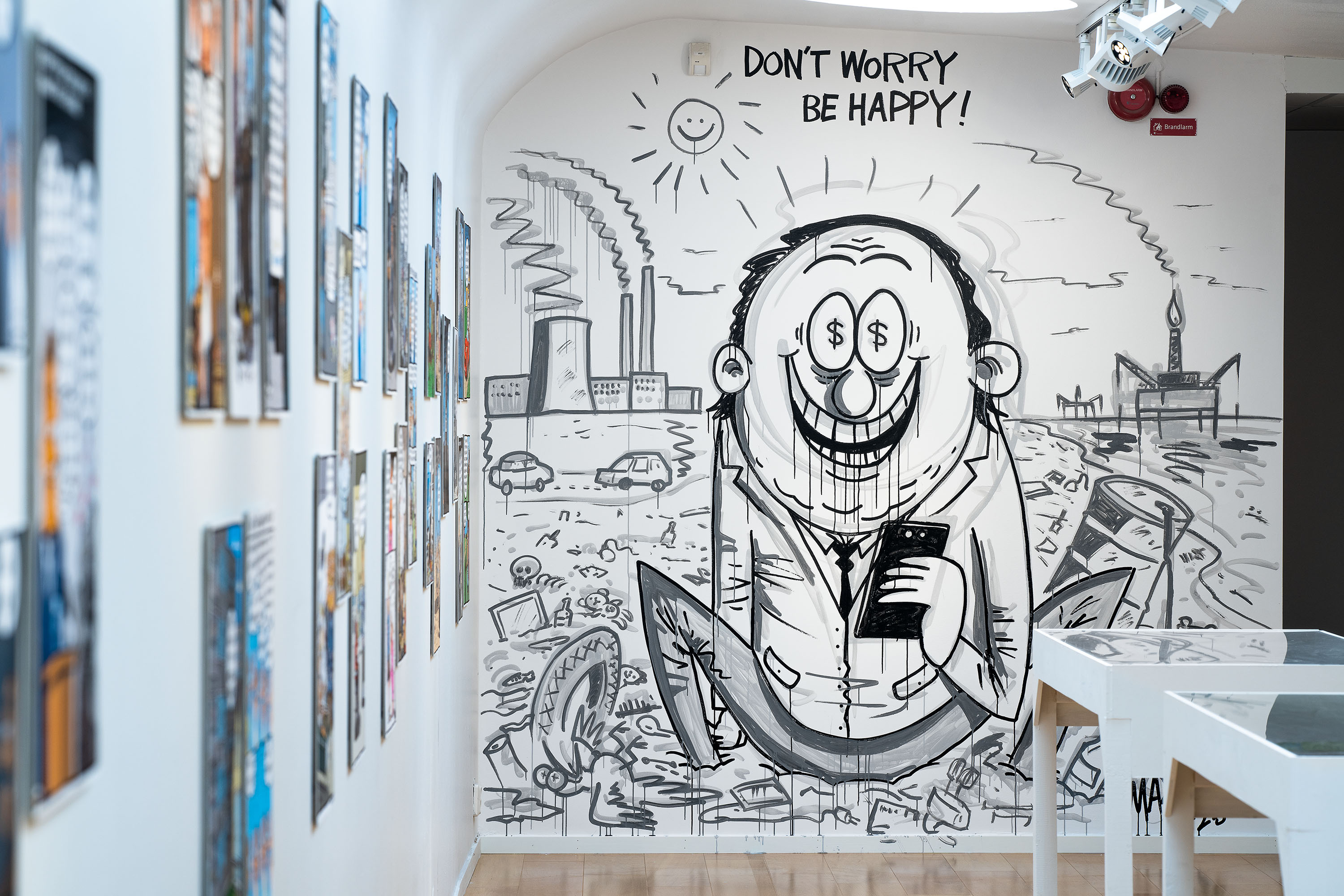 foto av väggmålning i svart mot vit vägg föreställande en satirfigur med stort leende