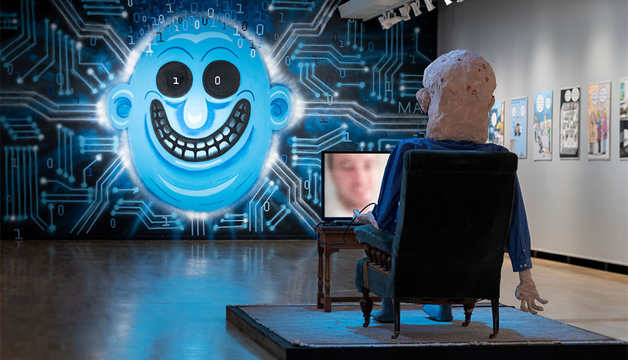 rumslig bild med en väggmålning med ett stort blått ansikte och en skulptur i förgrunden föreställande en person som tittar på TV