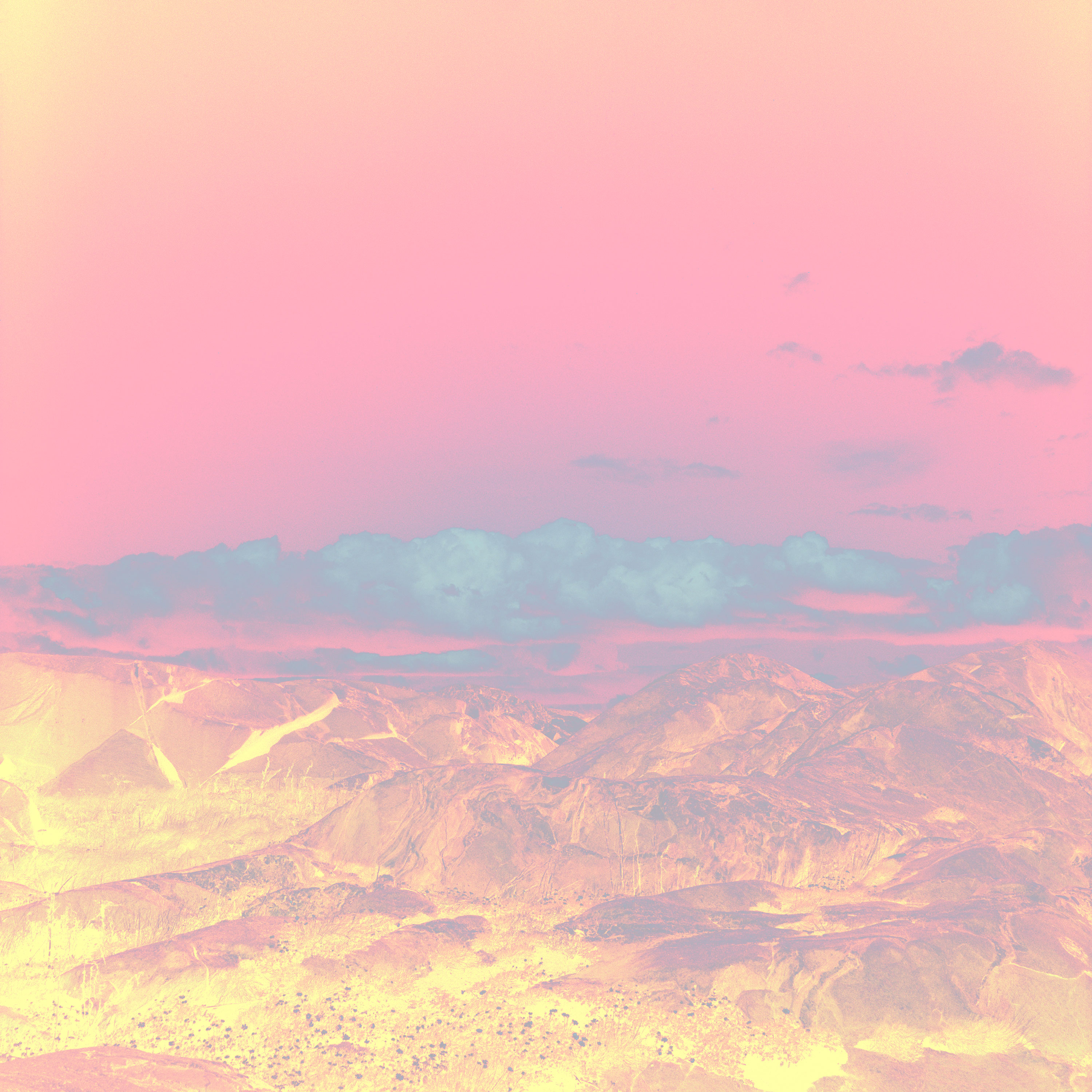 landskapsbild över hav och berg med förändrade färger i rosa och gult och orange
