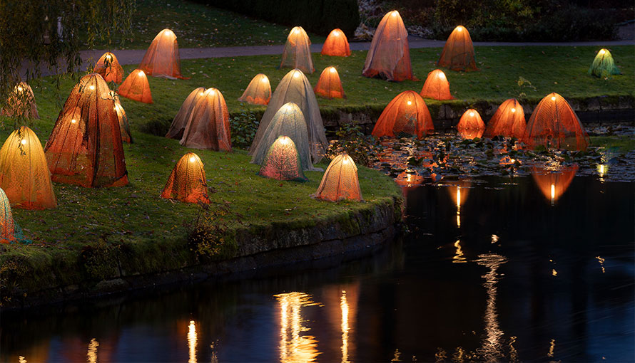 foto utomhus i kvällsmörker med lysande skulpturer i nät, som små spöken