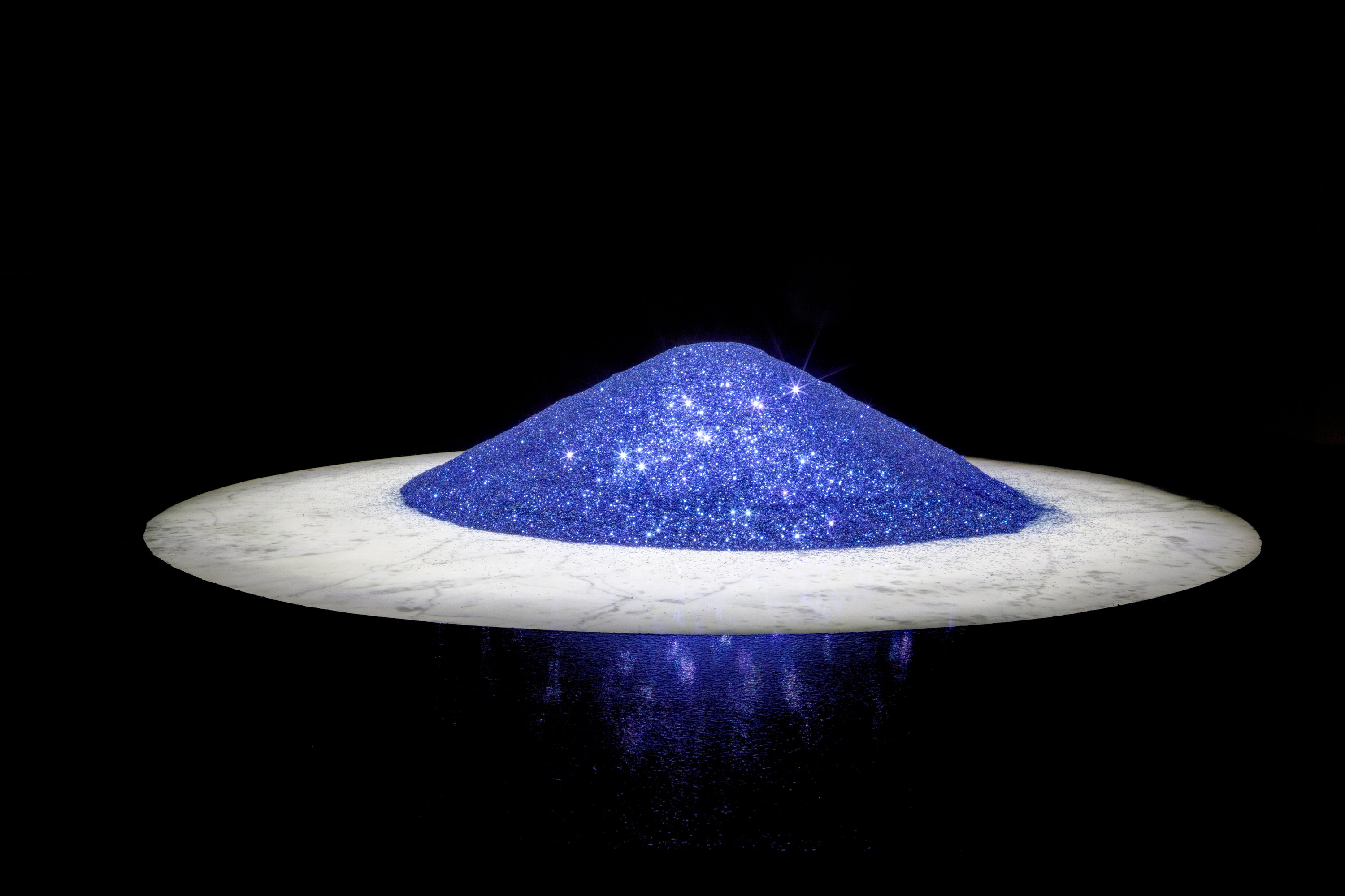 foto av en hög med blå stjärnstoft på ett runt fat
